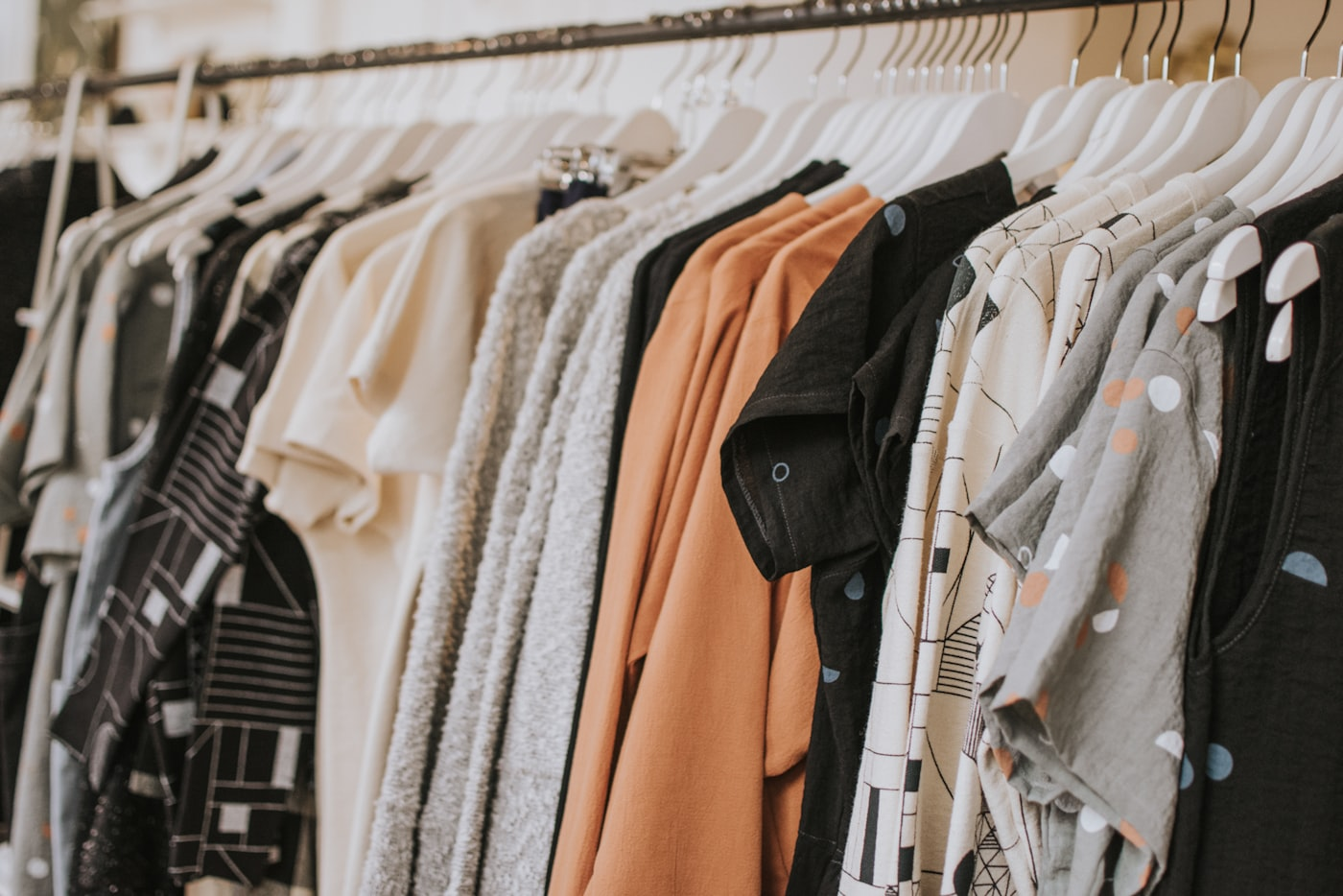 Thrifted clothing on a rack for measurements, labels, and condition review for Cookie Policy